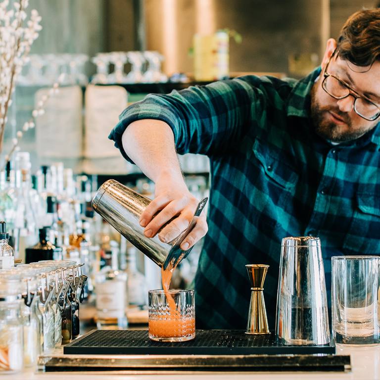 Bartender at Annette pours creative cocktail in Aurora Colorado