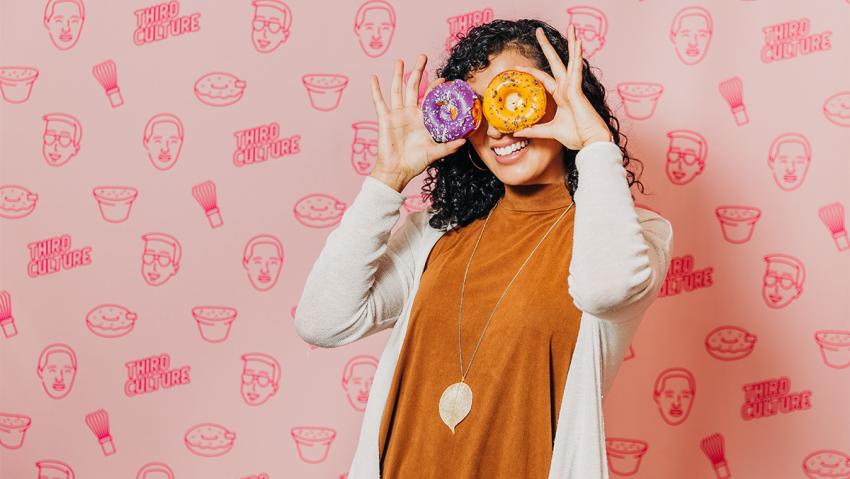 A girl holds up a mochi donut at Third Culture Bakery in Aurora CO