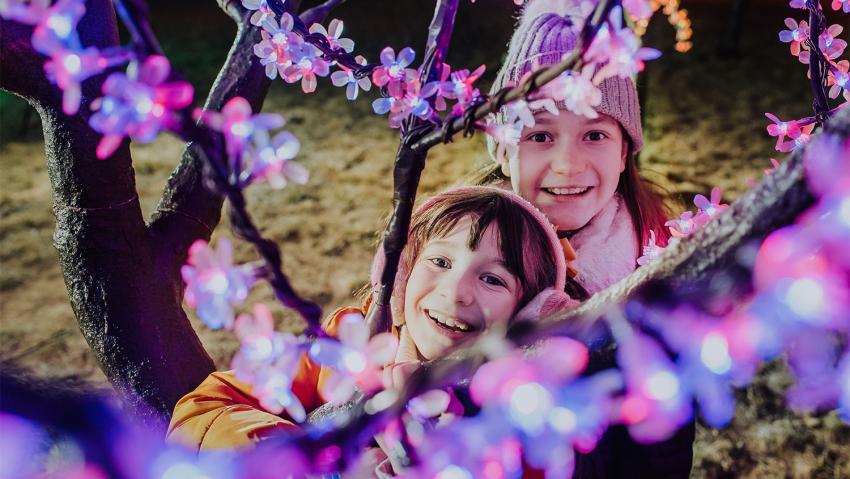 Two sisters smile among the LIGHT! exhibit at Gaylord Rockies in Aurora Colorado