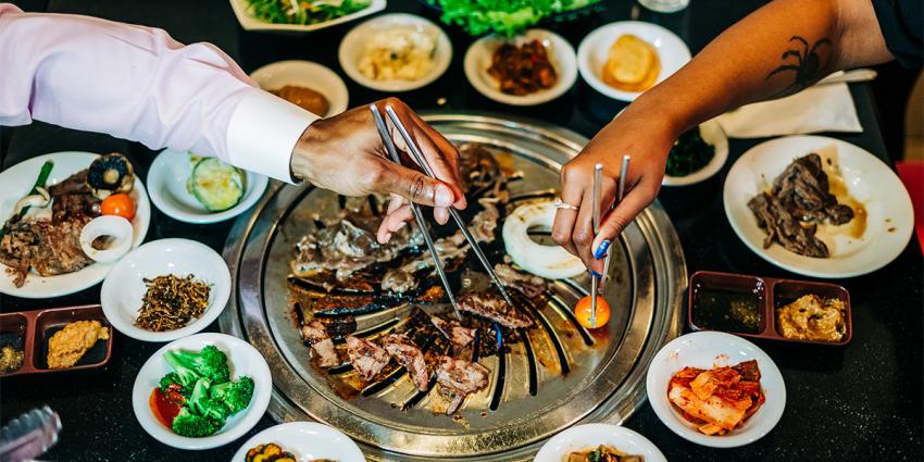 A young couple shares a tabletop grill used for Korean BBQ in Aurora Colorado
