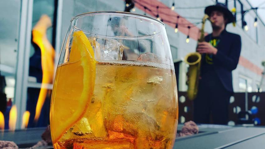 An orange cocktail sits on the patio at The Neighborhood Lounge in Aurora Colorado