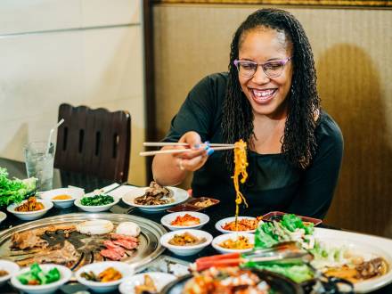 Young woman enjoys a huge spread of noodles in Aurora CO