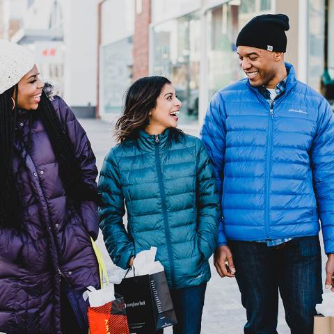 Three friends carry shopping bags through Southlands Shopping Center in Aurora CO