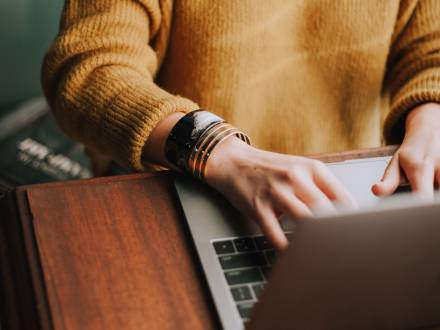 Woman types on her computer and works remote